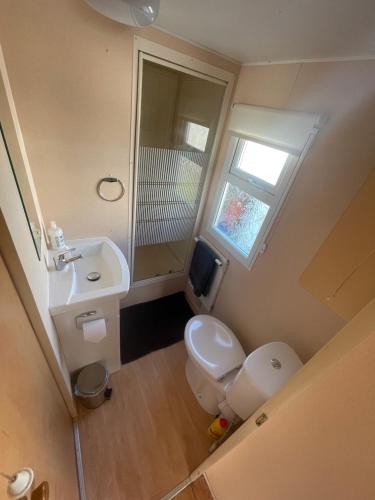a small bathroom with a toilet and a sink at 6 Berth Caravan on Sealands Site. Double Glazing in Ingoldmells