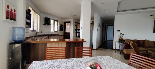 a kitchen and living room with a table and a kitchen and a table and chairs at English Point Residence Beach Apartments Mombasa in Mombasa
