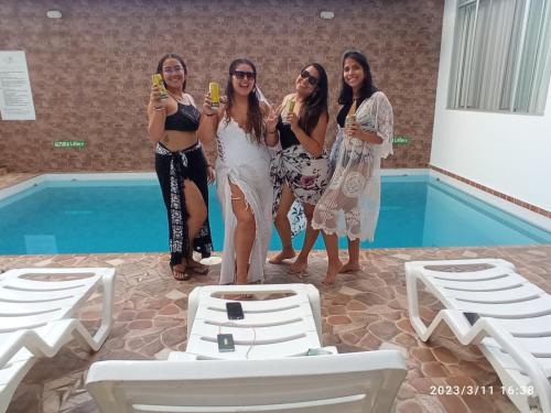 un grupo de mujeres de pie junto a una piscina en Posada del Angel Hotel, en Tarapoto