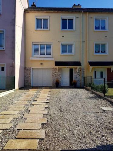 une grande maison avec une allée en pierre en face de celle-ci dans l'établissement Maison en location pour les 24h, au Mans