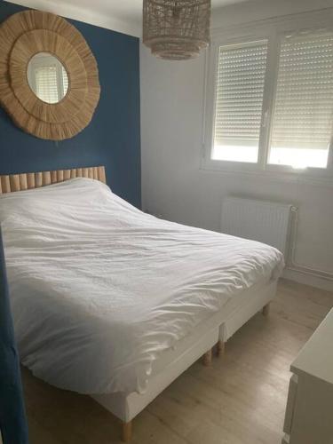 - un lit blanc dans une chambre avec 2 fenêtres dans l'établissement Maison en location pour les 24h, au Mans