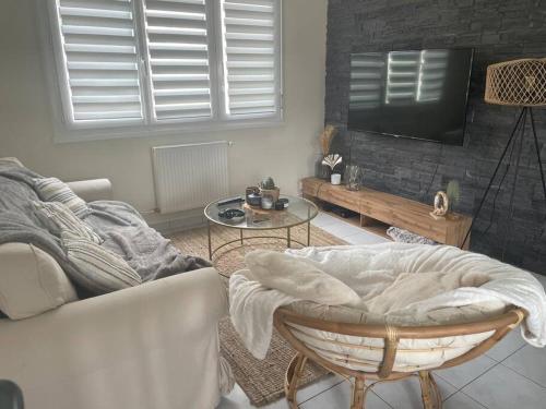 un salon avec un canapé et une télévision dans l'établissement Maison en location pour les 24h, au Mans