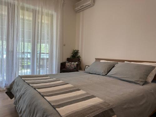- une chambre avec un grand lit et une fenêtre dans l'établissement Apartmani Roko, à Biograd na Moru