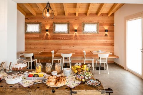 Agriturismo al Comarel في Tarzo: غرفة طعام مع طاولة عليها طعام