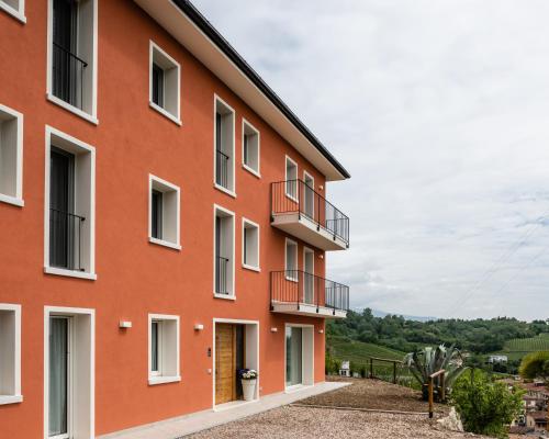 ein orangefarbenes Gebäude mit Balkonen an der Seite in der Unterkunft Agriturismo al Comarel in Tarzo