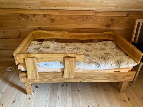 a wooden bed in a room with a wooden wall at Gabel&Jurgen in Mirsk