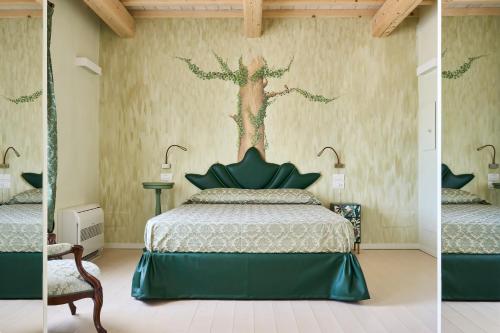 Agriturismo Borgonuovo في ريميني: غرفة نوم بسرير وشجر على الحائط