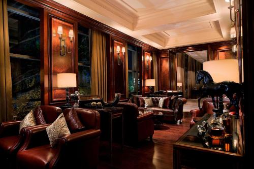 a living room with leather furniture and a horse statue at JW Marriott Pune in Pune