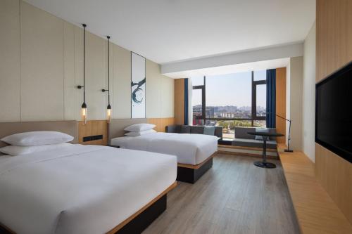 a hotel room with two beds and a flat screen tv at Fairfield by Marriott Danyang in Danyang