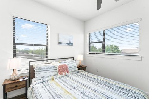 a white bedroom with a bed and two windows at Luxe East Downtown 3BR Condo, Walk to Bars, Restaurants, Shops in Austin