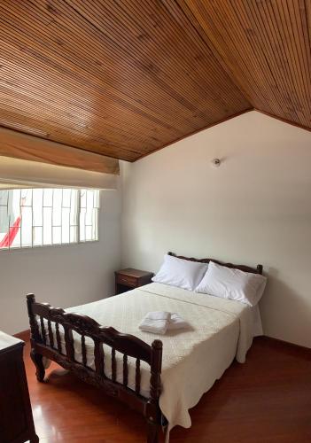 - une chambre avec un grand lit et un plafond en bois dans l'établissement CASA BLANCA, à Sogamoso