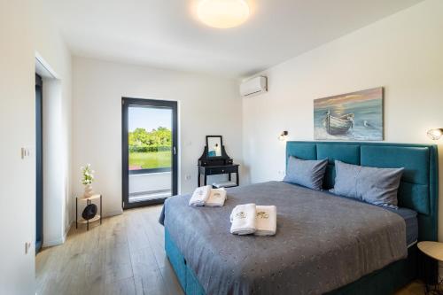 Un dormitorio con una cama azul con toallas. en Villa Noah, en Šišan