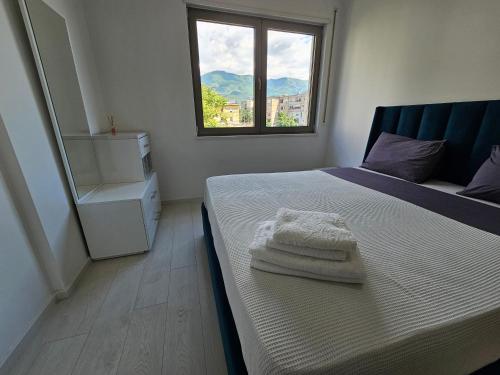 een slaapkamer met een bed met handdoeken erop bij Tower Bridge Apartment in Tirana