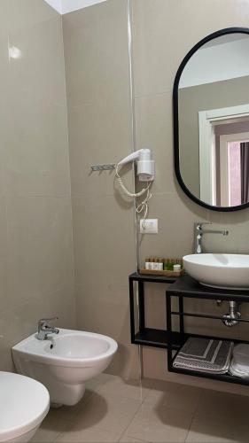 a bathroom with a sink and a mirror at Domus Hotel & Apartments in Shëngjin