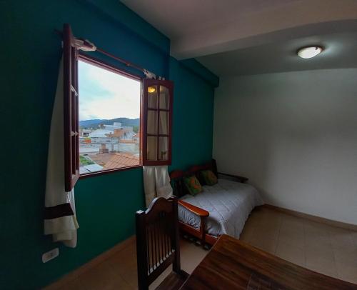 1 dormitorio con cama y ventana grande en Sonqo Departamentos en San Salvador de Jujuy