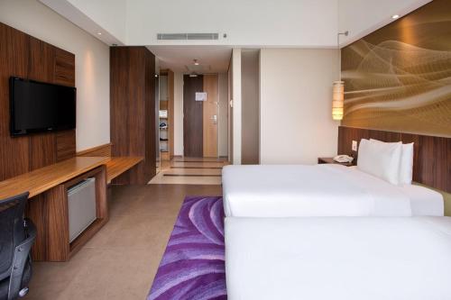 a hotel room with a bed and a flat screen tv at Holiday Inn Bandung Pasteur by IHG in Bandung