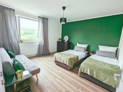 a bedroom with two beds and a green wall at Schöne Wohnung mit Balkon/Parkplatz/Aufzug in Hagen