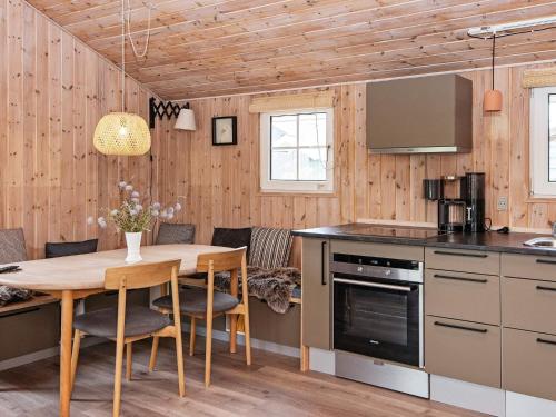 a kitchen and dining room with a wooden ceiling at 4 person holiday home in Hemmet in Hemmet