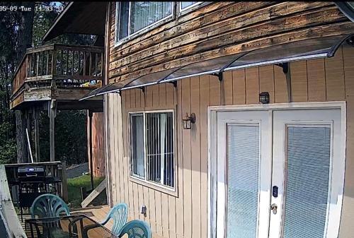 a house with a porch and a deck with chairs at Hidden Views B Duplex in Twain Harte