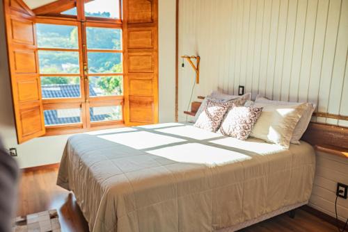 sypialnia z dużym łóżkiem i oknem w obiekcie Casarão do Vale dos Vinhedos w mieście Bento Gonçalves