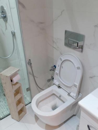 a white bathroom with a toilet and a shower at résidence Copacabana mehdia in Kenitra