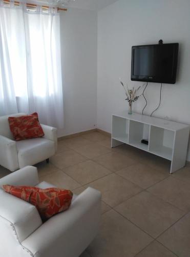 sala de estar con sofá blanco y TV en La Esquina en San Rafael