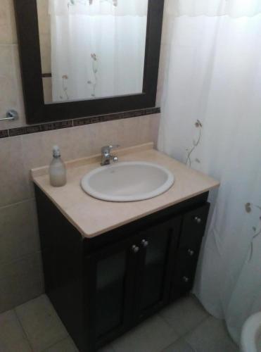 lavabo en el baño con un espejo grande encima. en La Esquina en San Rafael