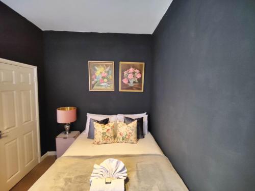 a bedroom with a bed with a gray wall at John Street Apartments Flat 2 in Bristol