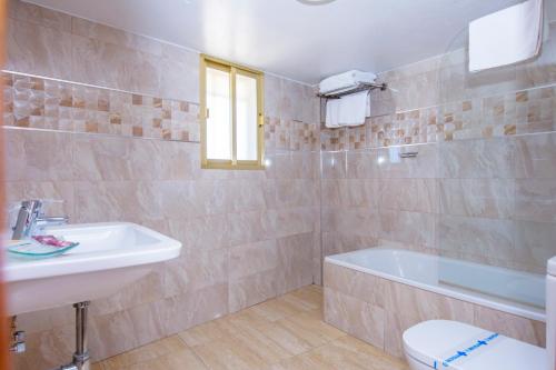 een badkamer met een wastafel, een bad en een toilet bij Miramar in Carboneras