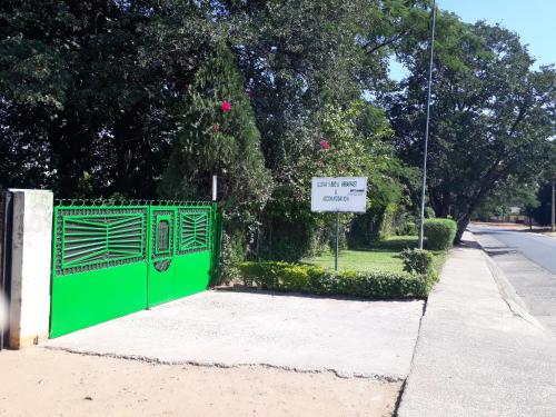 a green fence with a sign on the side of a street at Gloria's Bed and Breakfast in Livingstone