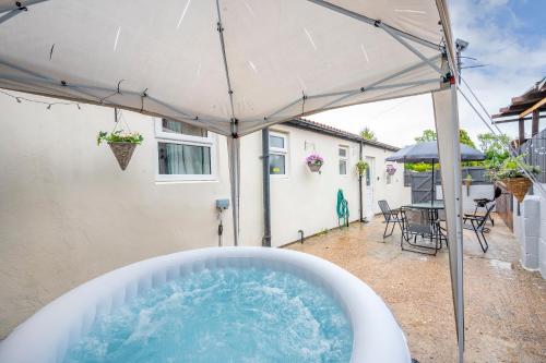 a hot tub in a backyard with an umbrella at *2a* ground floor house setup for your most amazing & relaxed stay + Free Parking + Free Fast WiFi in Beeston