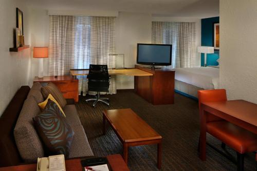 a hotel room with a couch and a bed and a television at Residence Inn Danbury in Danbury