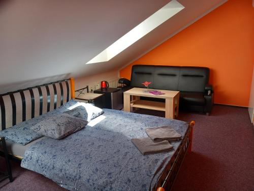 een slaapkamer met een bed, een stoel en een tafel bij Penzion Vulture Ostrava in Ostrava