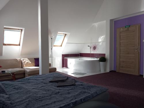een slaapkamer met een bed, een wastafel en een bank bij Penzion Vulture Ostrava in Ostrava