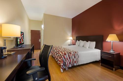 a hotel room with a bed and a desk at Red Roof Inn Hendersonville in Hendersonville