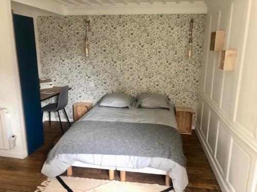 - une chambre avec un lit et un mur orné de papier peint floral dans l'établissement LE GARENGEOT - WIFi - CENTRE VILLE - PROPERTY RENTAL NM, à Vitré