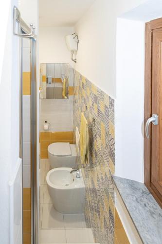 a bathroom with a white toilet and a sink at La Casa degli Dei in San Gimignano