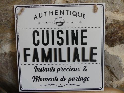 a sign hanging on a stone wall at La grange du Contourés in Castanet