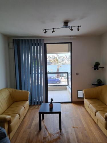 a living room with two couches and a table at Holiopolis in St Paul's Bay