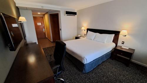 a hotel room with a bed and a television at Hotel Diego de Almagro Iquique in Iquique