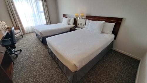 a hotel room with two beds and a window at Hotel Diego de Almagro Iquique in Iquique