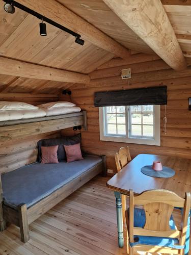 Zimmer mit Etagenbetten und einem Tisch in einer Hütte in der Unterkunft Weistad in Heidal