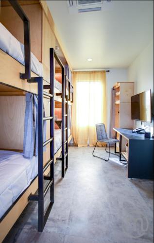 a dorm room with bunk beds and a desk at The Monterey Motel in Albuquerque