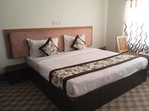 a bedroom with a large bed with pillows on it at Norbooling HomeStay, Leh Ladakh in Leh