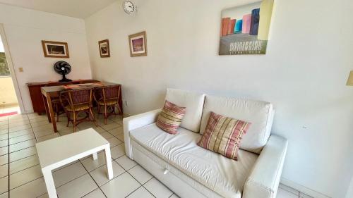 ein Wohnzimmer mit einem weißen Sofa und einem Tisch in der Unterkunft Yacht Village 106 Praia - NBI - Ponta Negra in Natal