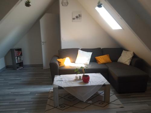 ein Wohnzimmer mit einem Sofa und einem Tisch in der Unterkunft la maison des taillis in Saint-Paul