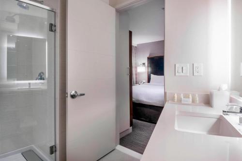 a bathroom with a sink and a bathroom with a bed at Residence Inn by Marriott Jersey City in Jersey City