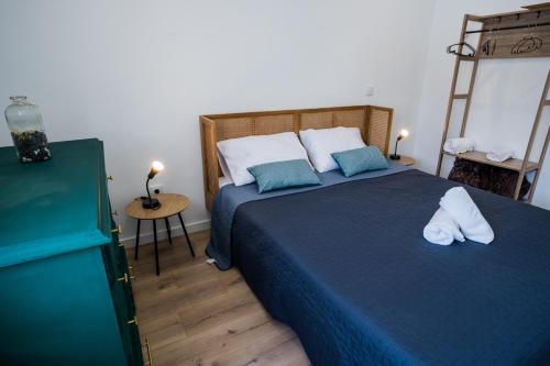 1 dormitorio con 1 cama azul y 2 almohadas en Forte Beach House, en Nazaré