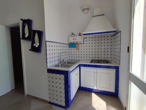 a small kitchen with a sink and blue tiles at B&B Punta Cutieri in Gallipoli