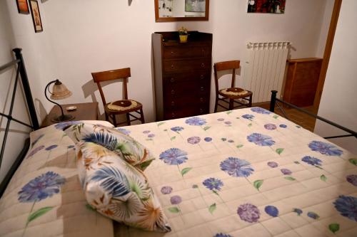 a bedroom with a bed with blue flowers on it at IL TUFO E LA CASCATA in Pitigliano